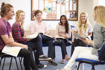 Eine Gruppe von Teenagern sitzt in einem Sesselkreis