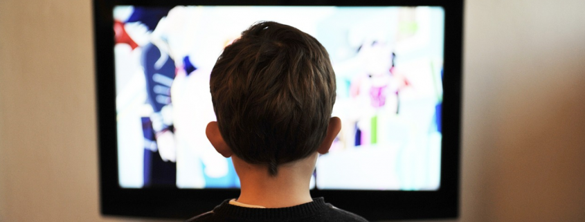 Ein Kind sitzt vor dem Fernseher.