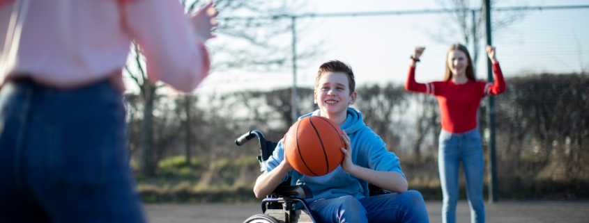 Bursche im Rollstuhl spielt Basketball Freunden