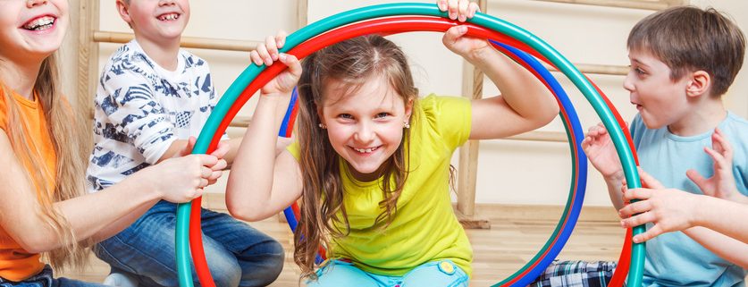 Fröhliche Kinder spielen mit Hulahoop-Reifen