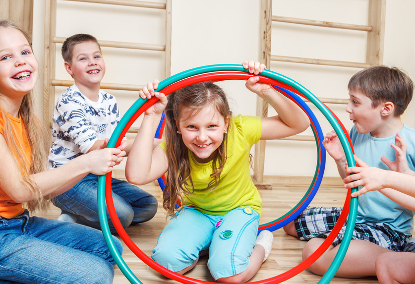Fröhliche Kinder spielen mit Hulahoop-Reifen