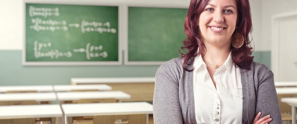 Lächelnde Lehrerin in leerem Klassenzimmer